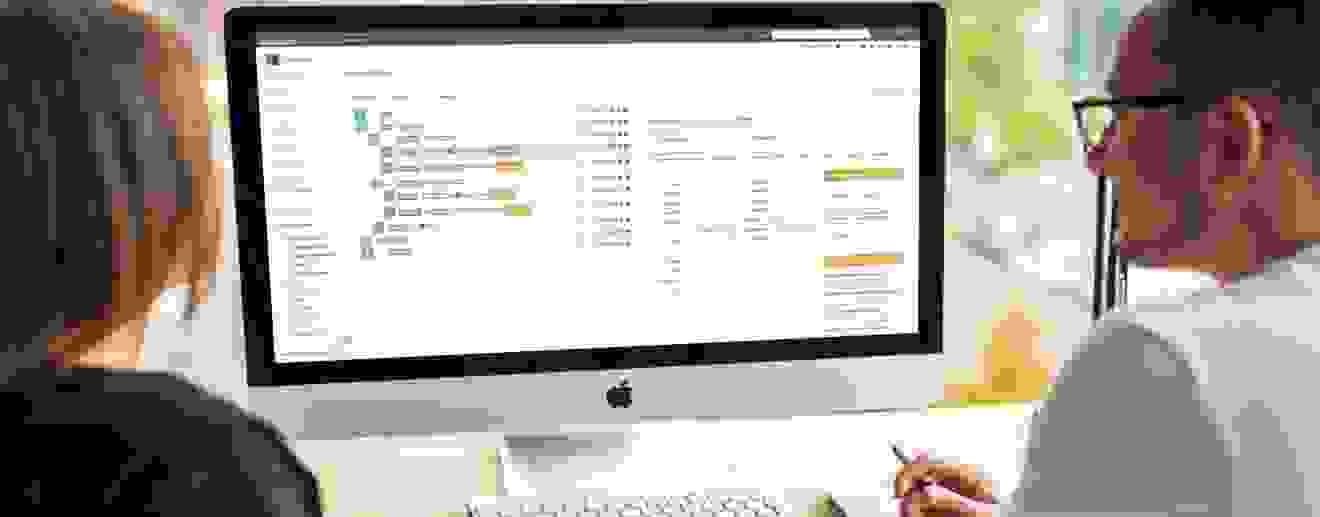 Mann und Frau benutzen am iMac Software der GEBRA-IT