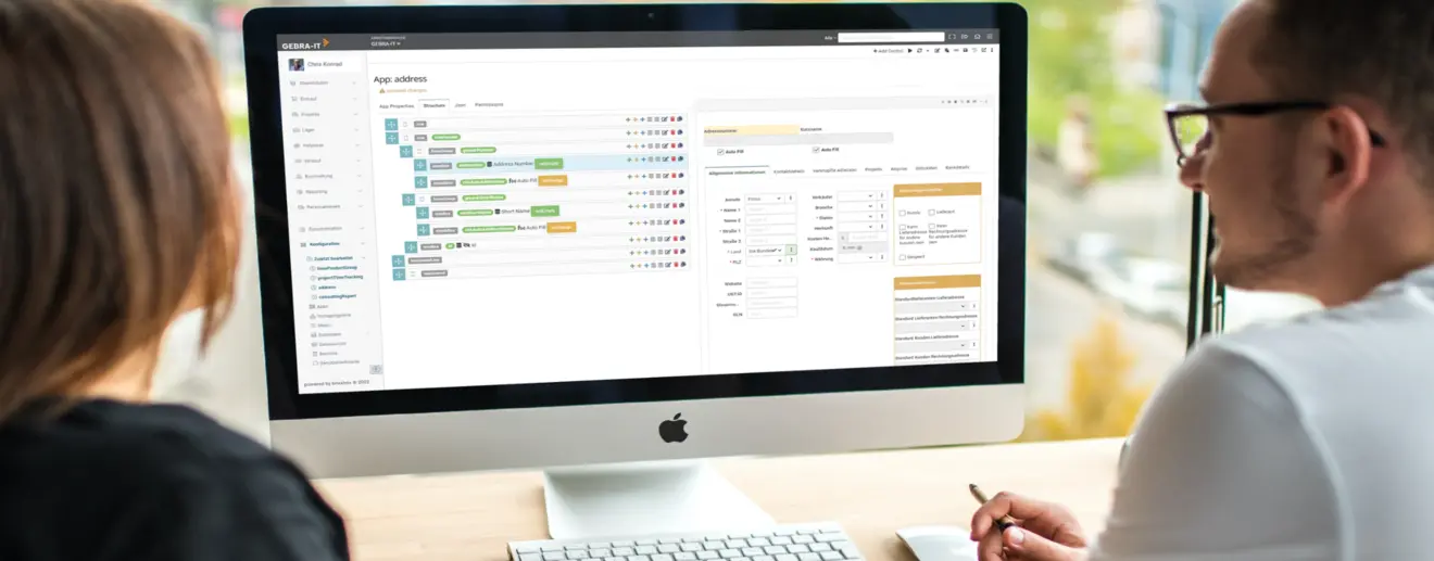 Mann und Frau benutzen am iMac Software der GEBRA-IT