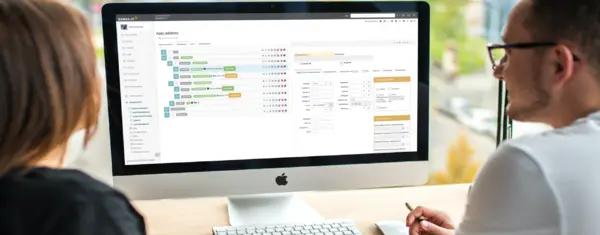 Mann und Frau benutzen am iMac Software der GEBRA-IT