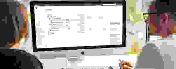 Mann und Frau benutzen am iMac Software der GEBRA-IT